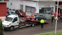 una grua retira uno de los coches siniestrados en la calle ayala